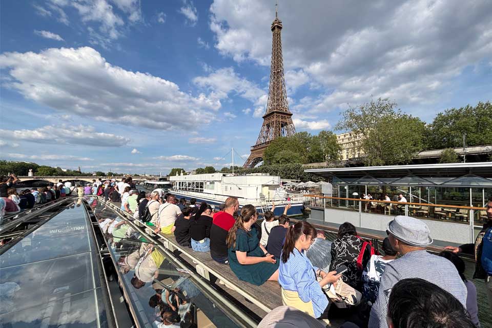 View of the Eiffel Tower as people sit on a boat during a one-hour Seine River boat tour